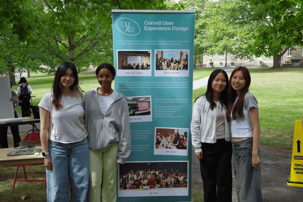 Ashley tabling for Cornell UX Design (CUxD) beside the club's banner