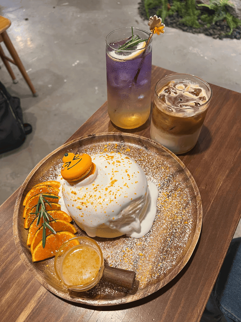 A café dessert plate with a tangerine macaron and iced drinks